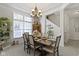 Elegant dining room featuring a chandelier, dining table set for six, and ample natural light from a large window at 15098 Newburyport Dr, Fortville, IN 46040