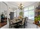 Cozy dining room with a dark wood table, chandelier, and a view into the entryway, bathed in natural light at 15098 Newburyport Dr, Fortville, IN 46040