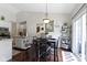 Bright dining area with a modern table set, stylish light fixture, and easy access to the kitchen and sliding glass door at 15098 Newburyport Dr, Fortville, IN 46040