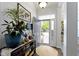 Inviting home entryway with stylish decor, a large houseplant, and natural light streaming through the open door at 15098 Newburyport Dr, Fortville, IN 46040