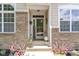 Charming front entrance featuring a 'Welcome' sign, brick accents, and decorative plants at 15098 Newburyport Dr, Fortville, IN 46040