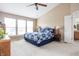 Bright bedroom with a ceiling fan, neutral walls, carpet, and a large bed with an adjacent bathroom at 1521 Midnight Pass, Brownsburg, IN 46112