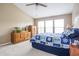 Bedroom featuring carpet, light beige walls, a fan, and wooden furniture with a patterned blue bedspread at 1521 Midnight Pass, Brownsburg, IN 46112