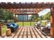 A wooden deck with a pergola, wicker sofa and chairs, with a view of the lawn and privacy fence at 1521 Midnight Pass, Brownsburg, IN 46112