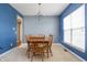 Bright dining room featuring blue accent walls, traditional chandelier, and wooden dining set at 1521 Midnight Pass, Brownsburg, IN 46112