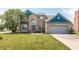 Charming two-story home with a well-manicured lawn, a gray two-car garage and brick facade at 1521 Midnight Pass, Brownsburg, IN 46112