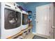 Laundry room features a front load washer and dryer, storage shelves, and access to outside at 1521 Midnight Pass, Brownsburg, IN 46112