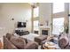 Open-concept living room with high ceilings, fireplace, large windows, and comfortable seating arrangement at 1521 Midnight Pass, Brownsburg, IN 46112