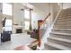 Bright living room featuring a fireplace, soaring ceilings, and a staircase with a wooden handrail at 1521 Midnight Pass, Brownsburg, IN 46112