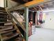 Unfinished basement with exposed ceiling, clothes rack, and stairs leading up to the main floor at 160 E Elm St, Morgantown, IN 46160