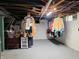 Unfinished basement area with visible pipes and ducts, clothing racks, and painted concrete floor at 160 E Elm St, Morgantown, IN 46160