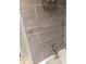 Close-up of bathroom tile showcasing modern gray tones and a mounted shower head fixture at 160 E Elm St, Morgantown, IN 46160