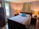 Comfortable bedroom featuring a bed with decorative pillows, warm lighting, and curtains at 160 E Elm St, Morgantown, IN 46160