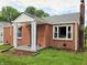 Beautiful red brick home featuring a covered porch with hanging plants and modern white windows at 160 E Elm St, Morgantown, IN 46160