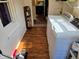 Bright laundry room with white washer and dryer, storage shelves, wood-look floors and natural light at 160 E Elm St, Morgantown, IN 46160