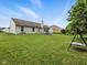 Large backyard featuring a playset and mature trees at 1702 Juniper Ln, Greenwood, IN 46143