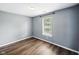 Cozy bedroom featuring wood-look floors, neutral paint, and a bright window at 1702 Juniper Ln, Greenwood, IN 46143