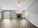 Bright living room featuring hardwood floors, a brick fireplace, and large windows overlooking the backyard at 1702 Juniper Ln, Greenwood, IN 46143