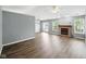 Open-concept living room featuring a cozy brick fireplace, wood floors, and ample natural light at 1702 Juniper Ln, Greenwood, IN 46143