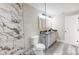 Modern bathroom with double vanity, tiled shower, and gray wood-look floor at 1809 S H St, Elwood, IN 46036