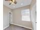 Bright, carpeted bedroom with a window, ceiling fan, and a door, creating a comfortable living space at 1809 S H St, Elwood, IN 46036
