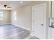 View of the living room featuring updated flooring, neutral walls, and windows allowing natural light at 1809 S H St, Elwood, IN 46036
