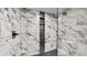 Close-up of tiled shower with built-in shelf and glass door at 1809 S H St, Elwood, IN 46036