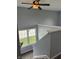 Hallway boasts plush carpeting, complemented by a ceiling fan and sunlit window views at 19236 Fox Chase Dr, Noblesville, IN 46062
