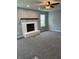 Cozy living room features plush gray carpet, a painted brick fireplace, and natural light at 19236 Fox Chase Dr, Noblesville, IN 46062