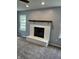 Living room with gray carpet, a painted brick fireplace, wood mantle, and bright windows at 19236 Fox Chase Dr, Noblesville, IN 46062