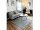 Cozy living room featuring hardwood floors and neutral decor with a comfortable couch and accent chair at 1940 N Drexel Ave, Indianapolis, IN 46218