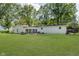Large backyard with well-maintained lawn, trees, and brick fire pit at 20797 Roberts Dr, Sheridan, IN 46069