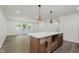 Bright open kitchen with white countertops and a large center island and modern lighting at 20797 Roberts Dr, Sheridan, IN 46069