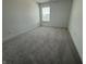 Neutral bedroom showcasing soft gray carpeting, a window providing natural light, and a serene, minimalist decor at 2954 Grand Rdg Dr, Greenwood, IN 46143