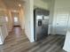 Hallway view with modern stainless steel refrigerator and grey wood-look flooring and white doors at 2954 Grand Rdg Dr, Greenwood, IN 46143