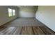 Spacious living room featuring plush gray carpeting, ample natural light from a double window, and stylish wood flooring detail at 2954 Grand Rdg Dr, Greenwood, IN 46143