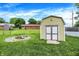 Backyard featuring a storage shed, fenced perimeter, and inviting fire pit area for entertainment at 3038 S Richardt Ave, Indianapolis, IN 46239