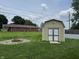The backyard has a shed, fire pit, green grass, and a chain link fence at 3038 S Richardt Ave, Indianapolis, IN 46239