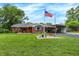 Charming single-story brick home featuring a lush green lawn and American flag at 3038 S Richardt Ave, Indianapolis, IN 46239
