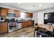 Kitchen with stainless steel appliances, vinyl floors, and access to the dining area at 3038 S Richardt Ave, Indianapolis, IN 46239