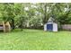 Backyard with shed and mature trees and shrubs; privacy fence lines the lot at 317 Heritage Ct, Fishers, IN 46038