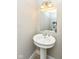 Stylish half bath features a pedestal sink, decorative mirror, and charming light fixture at 317 Heritage Ct, Fishers, IN 46038