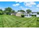 Expansive backyard view showcasing the lawn, garage, and sunroom at 3322 N Riley N Ave, Indianapolis, IN 46218