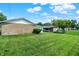 Large grassy backyard view highlighting a detached garage and sunroom at 3322 N Riley N Ave, Indianapolis, IN 46218