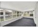 Bright sunroom featuring many windows, white trim, and carpeted floors at 3322 N Riley N Ave, Indianapolis, IN 46218