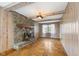 Bright living room features a stone fireplace, wood paneling, and wood floors at 3388 S Leonard Rd, New Palestine, IN 46163