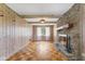 Bright living room features a stone fireplace, wood paneling, and wood floors at 3388 S Leonard Rd, New Palestine, IN 46163