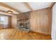Bright living room features a stone fireplace, wood paneling, and wood floors at 3388 S Leonard Rd, New Palestine, IN 46163
