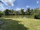 Scenic view of the community pond, framed by lush greenery and a clear blue sky with fluffy clouds at 3525 Valley Lake Dr, Indianapolis, IN 46227
