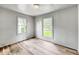 Bright bedroom featuring fresh paint, new wood flooring, and dual windows for natural light at 4034 N Temple Ave, Indianapolis, IN 46205